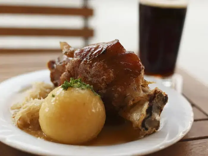 Schweinshaxe_mit_Kartoffelknödel_und_Sauerkraut_2x.webp