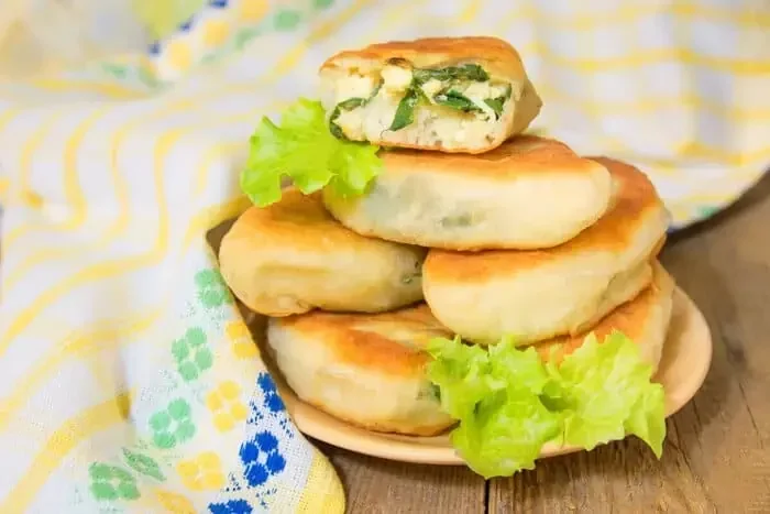 Gebratene-russische-Teigtaschen-Piroschki-mit-Zwiebeln-und-Eiern.webp